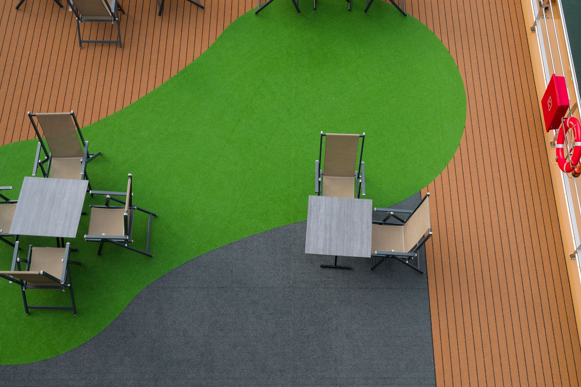Aerial view of an outdoor seating area on a deck with vibrant green and brown colors.